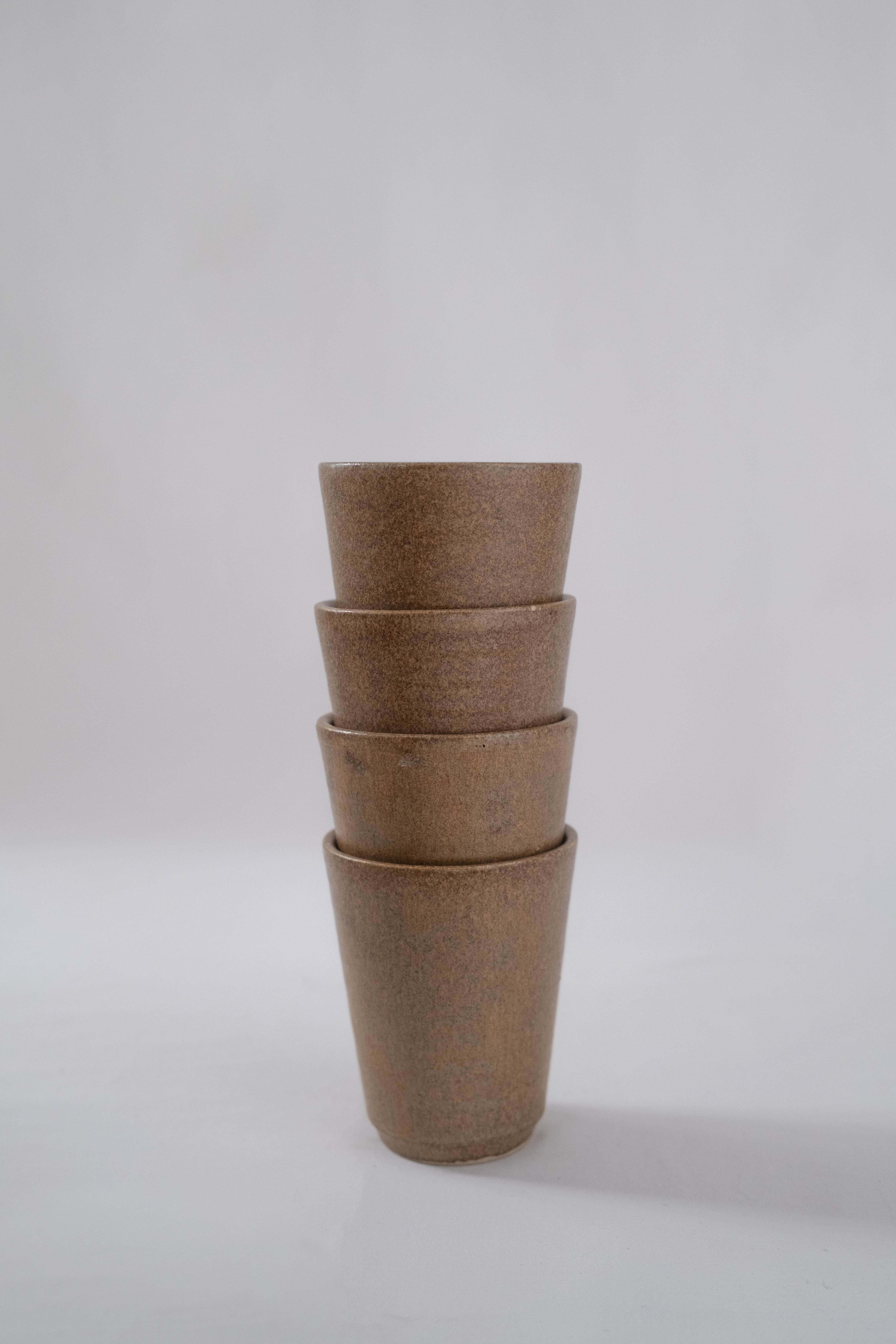 LOT DE QUATRE VERRES EN GRÈS MARRON
