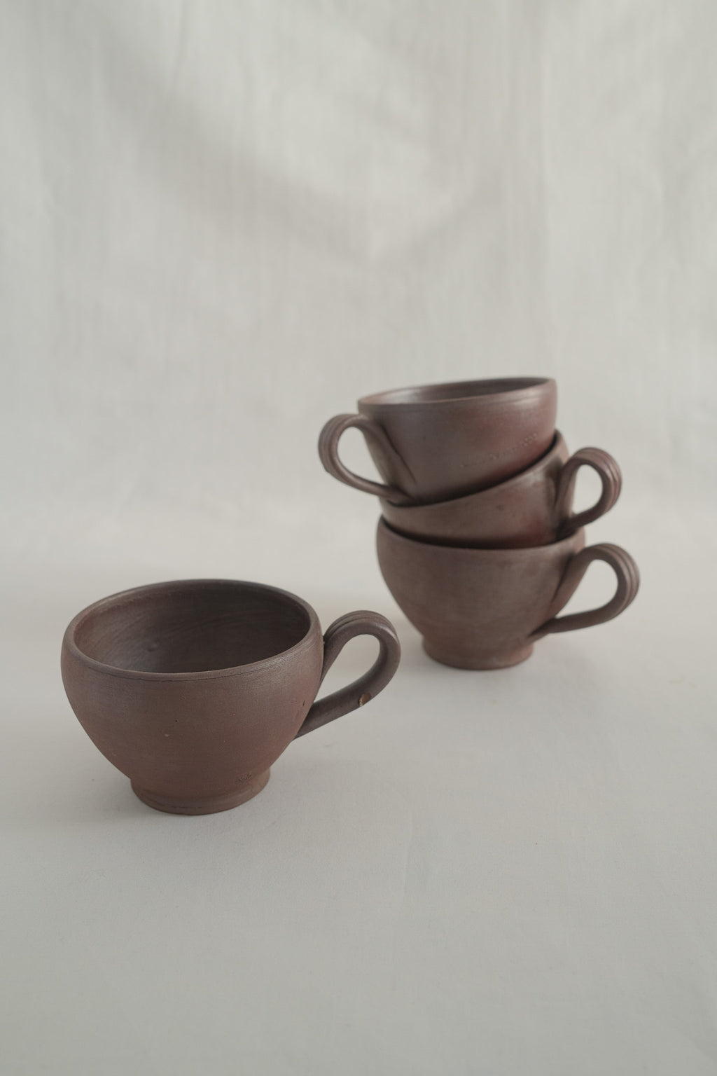 LOT DE QUATRE TASSES EN GRÈS PRUNE